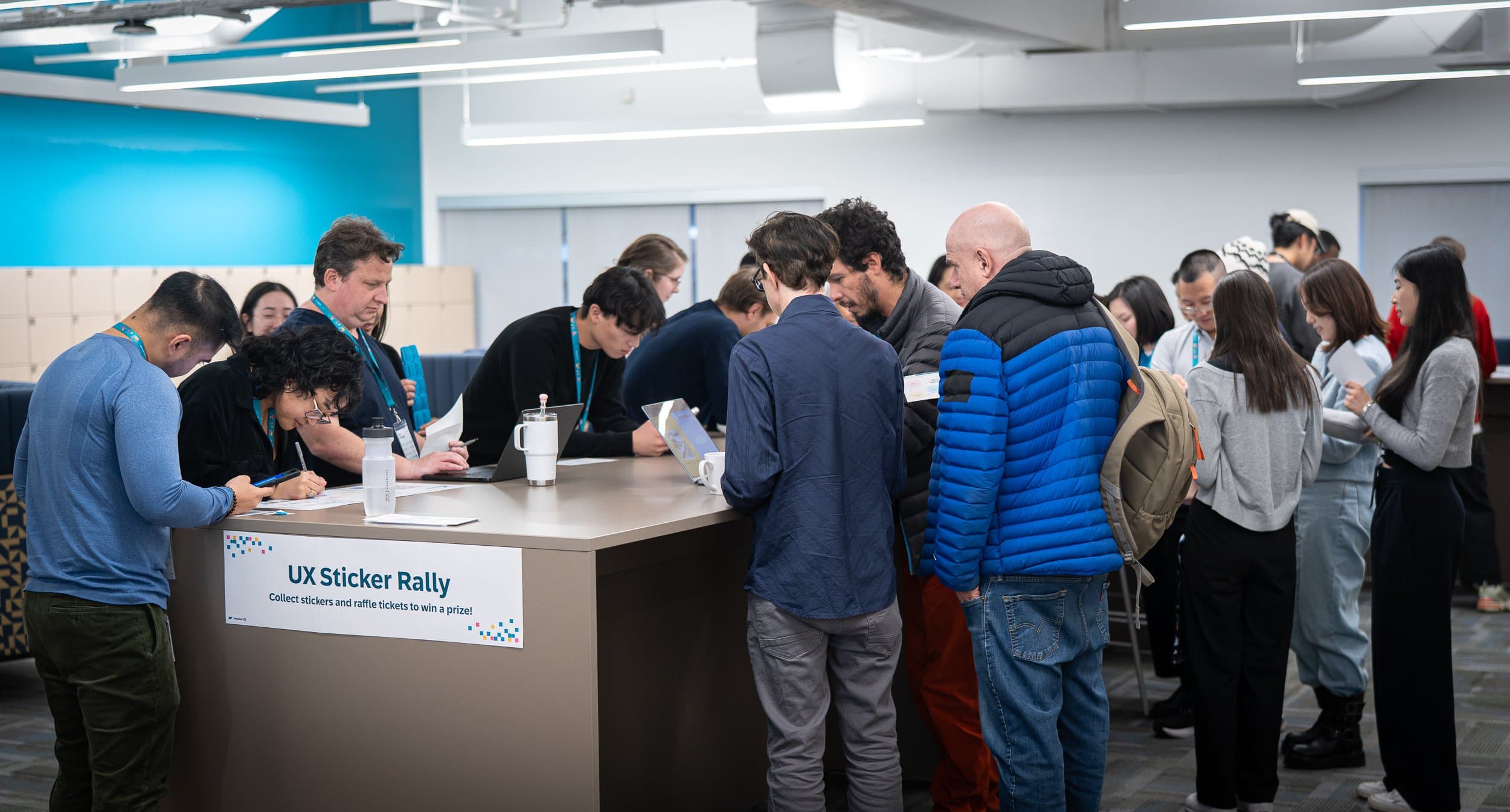 Attendees gathered around the UX Sticker Rally table at Impulse