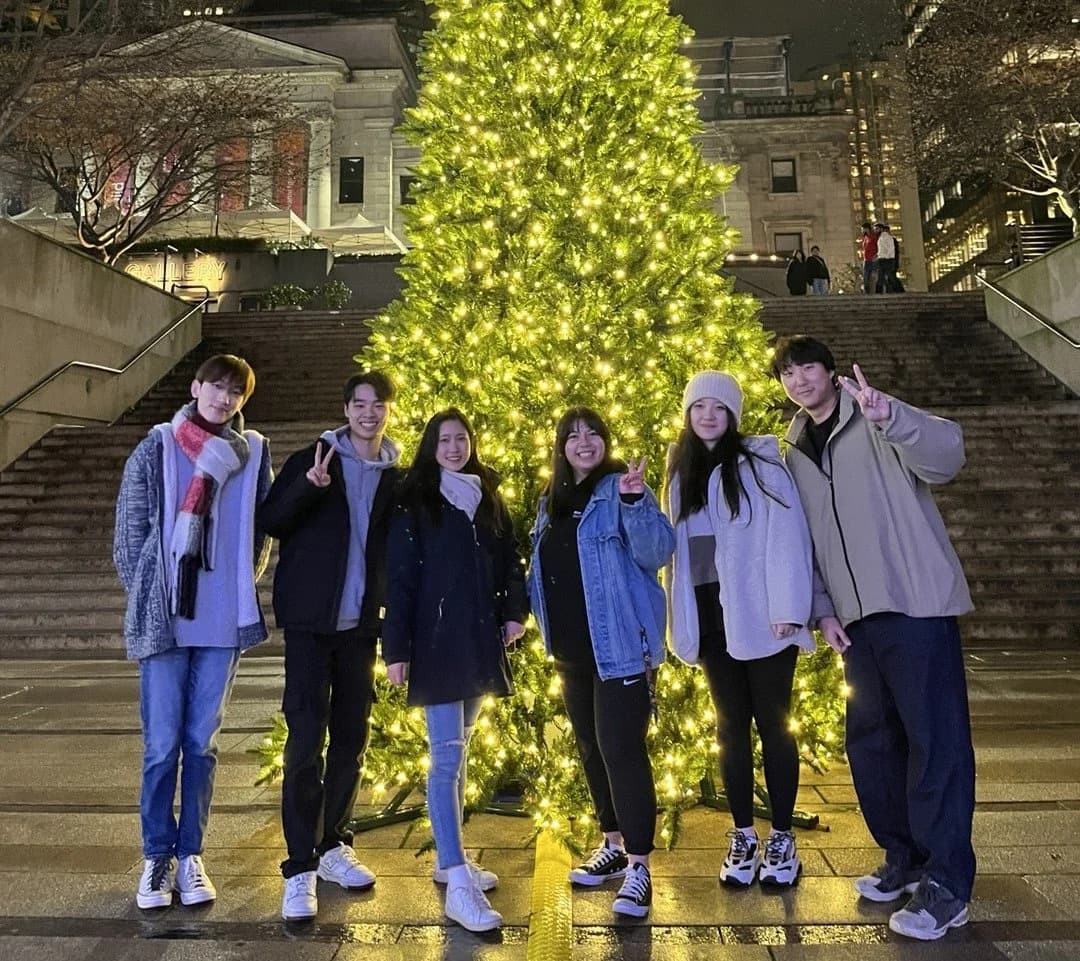 The team posing in front of a lit Christmas tree outside a gallery