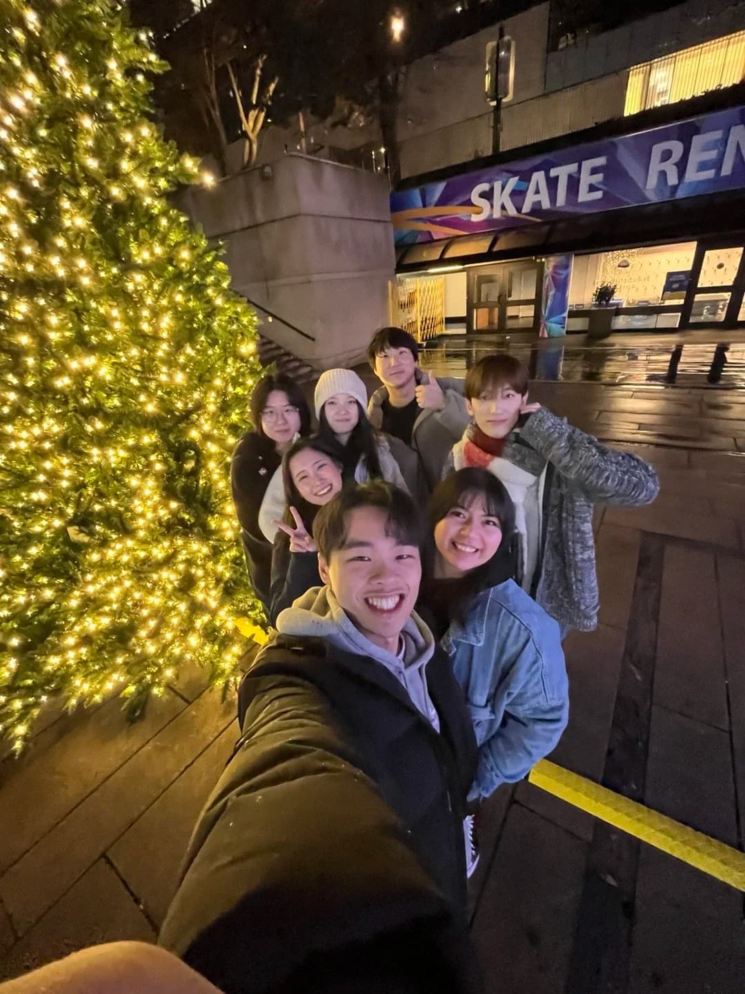 The team taking a group selfie in front of a Christmas tree