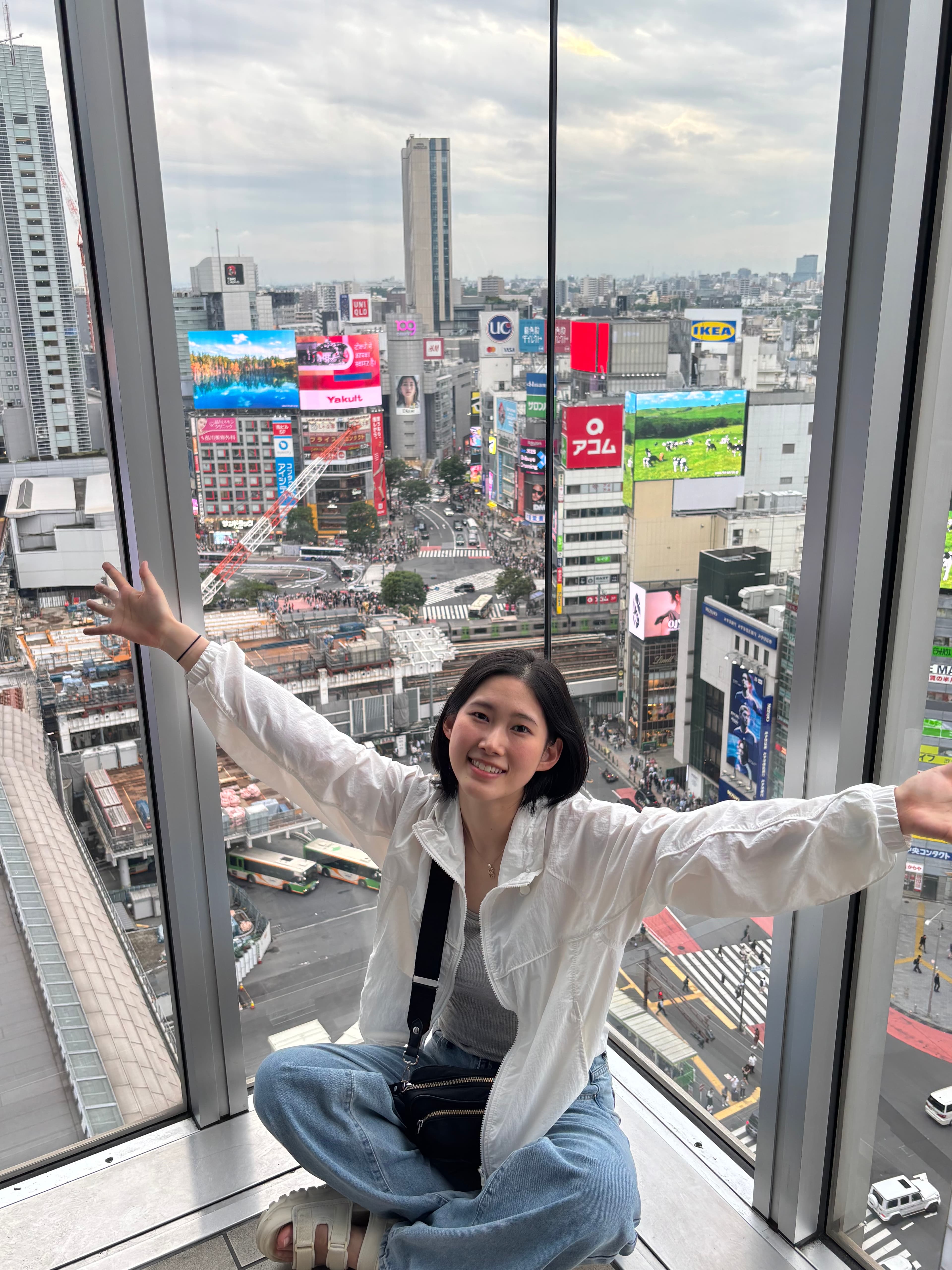 Reina by a window overlooking the city