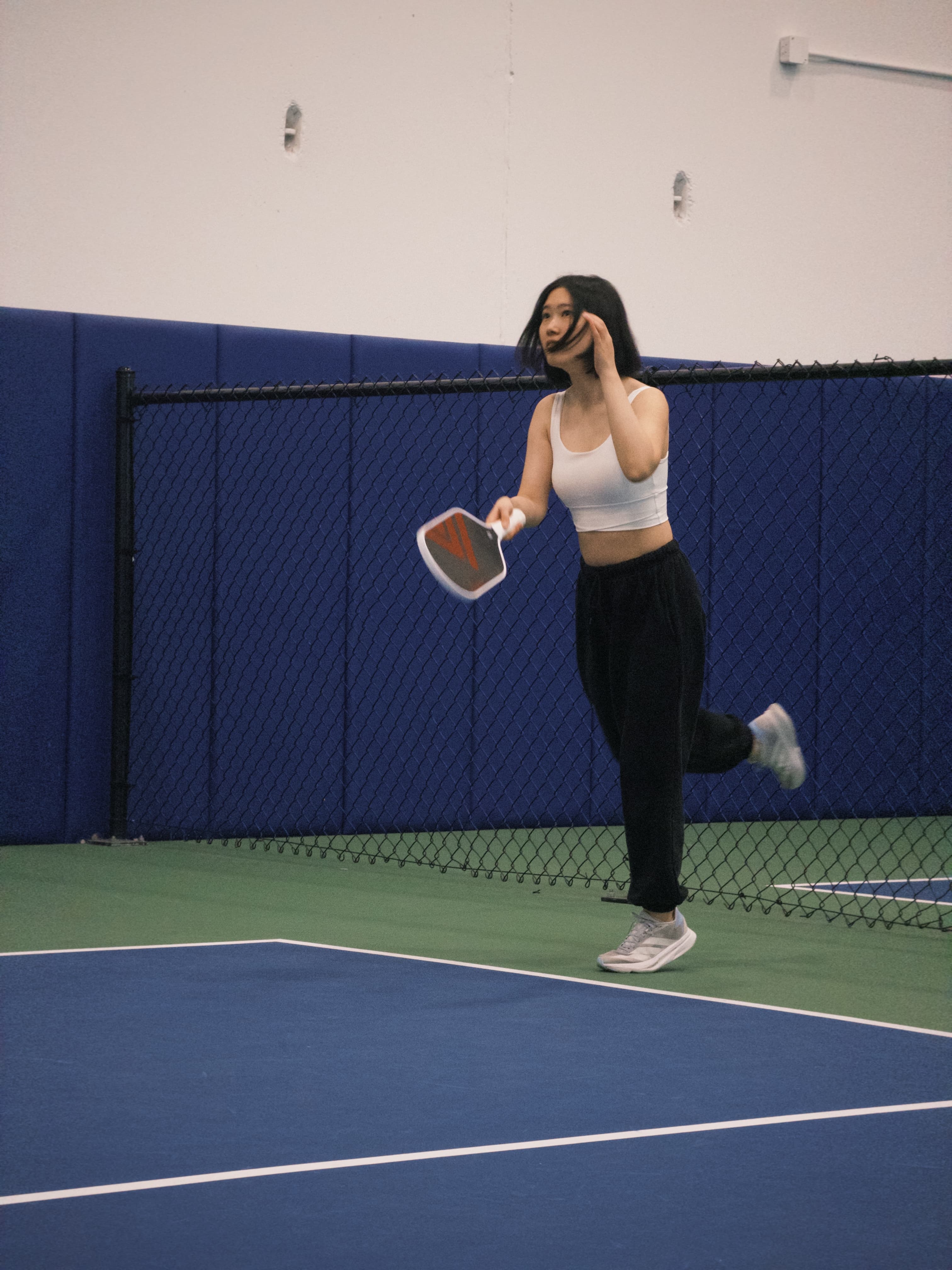 Reina holding a paddle on an indoor court
